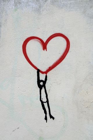 Picture of grafiti person holding up a heart